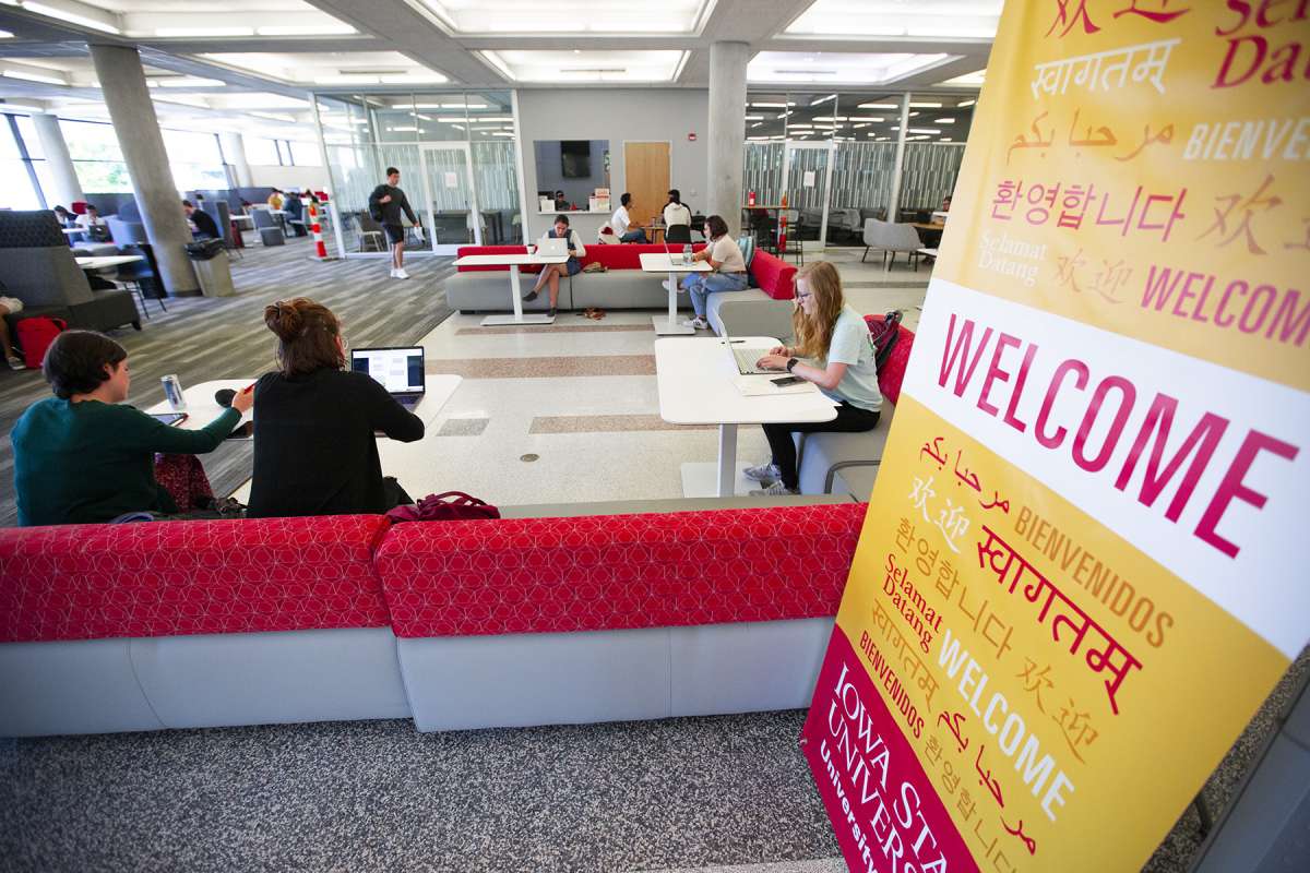 Students sit in the new Parks Library study ares with a welcome sign in multiple languages